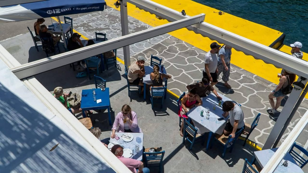 Blue tables on the waterfront terrace at Lombranos