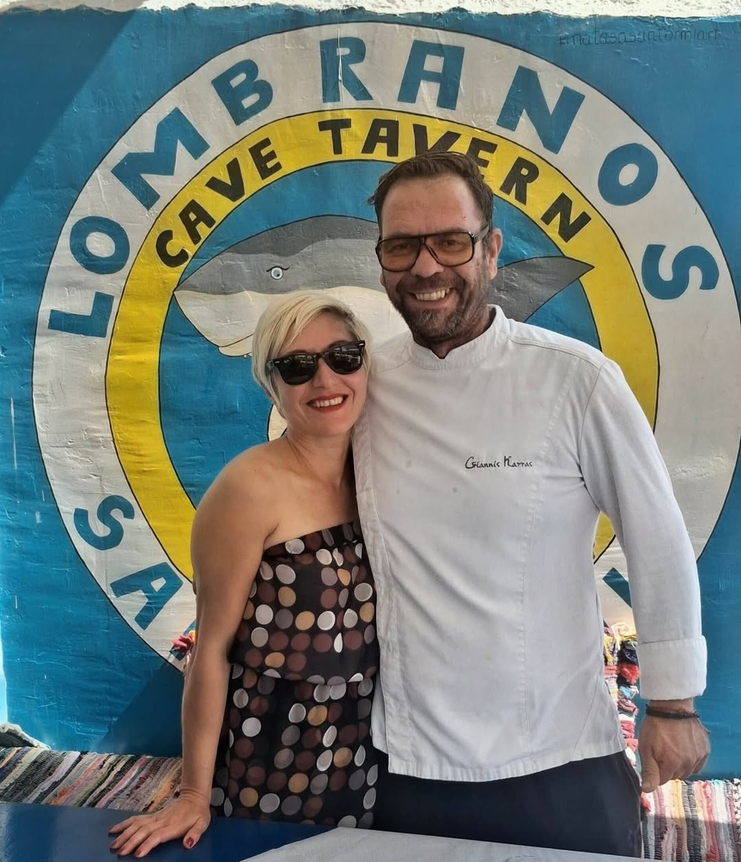 Chef in front of the hand-painted Lombranos Cave Tavern sign